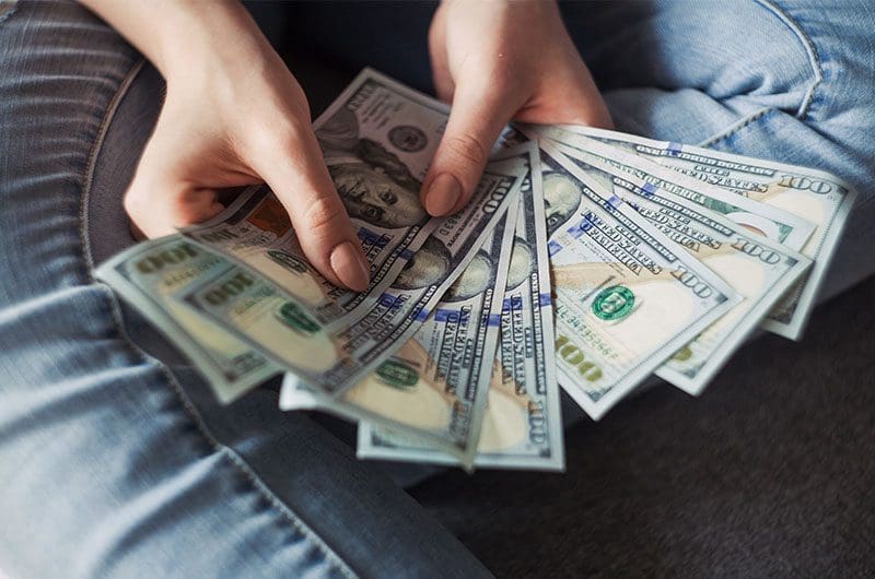 Two hands holding currency notes