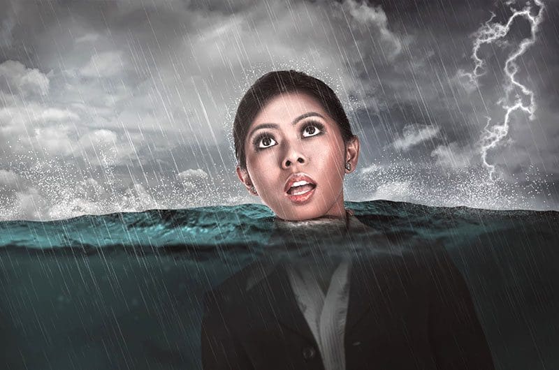 A business woman drowning in water