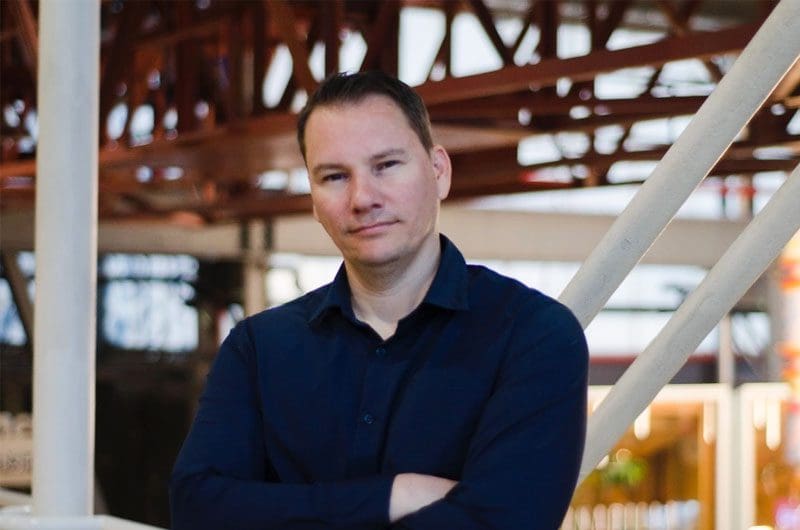 a man standing in a warehouse with his arms crossed